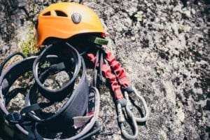 Équipement complet de via ferrata avec casque, harnais et longes posé sur un rocher à Guillestre dans les Hautes-Alpes.